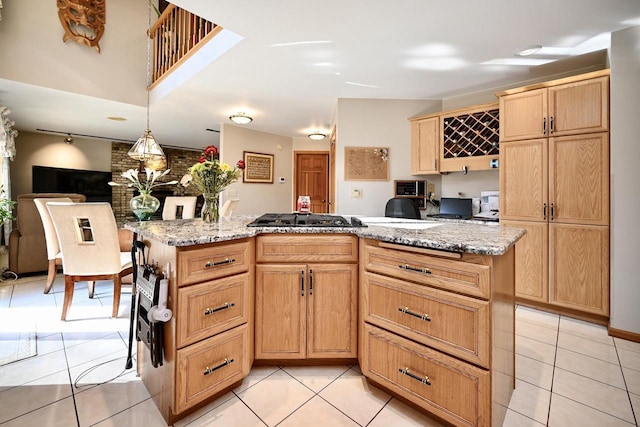 kitchen with gas cooktop, pendant lighting, light tile patterned flooring, and light stone countertops