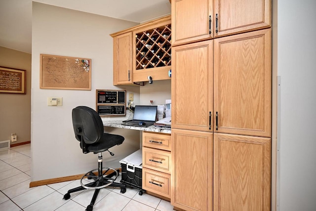 office area with light tile patterned flooring, visible vents, baseboards, and built in study area