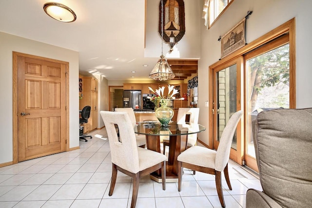 dining room featuring light tile patterned floors, baseboards, and a wealth of natural light