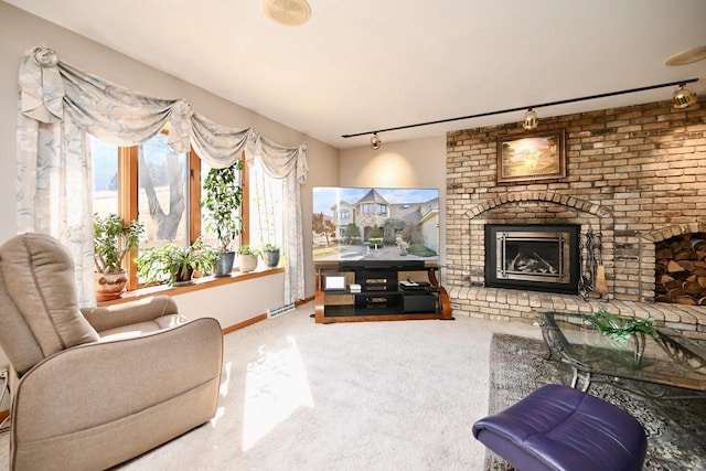 living area with visible vents, carpet floors, baseboards, a fireplace, and rail lighting