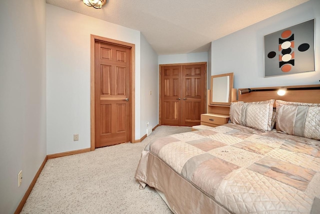 bedroom featuring carpet, baseboards, a closet, and a textured ceiling