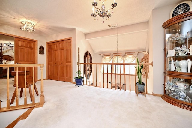 carpeted entrance foyer featuring a notable chandelier, a textured ceiling, lofted ceiling with beams, and baseboards