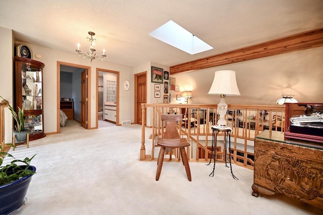 living area featuring visible vents, baseboards, light carpet, a skylight, and a notable chandelier