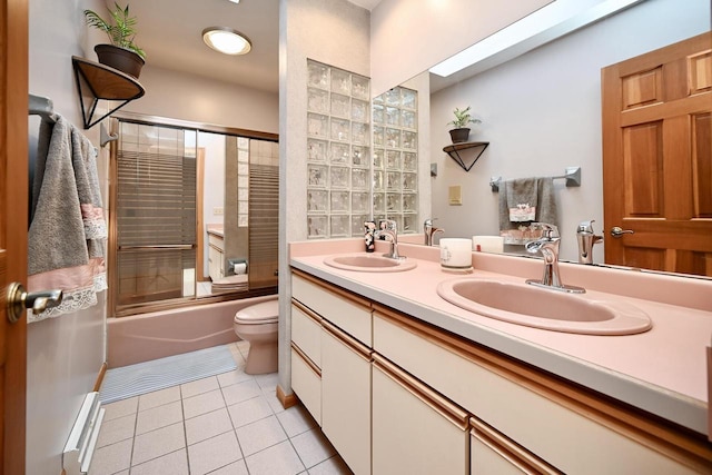 bathroom featuring a sink, toilet, double vanity, and tile patterned flooring