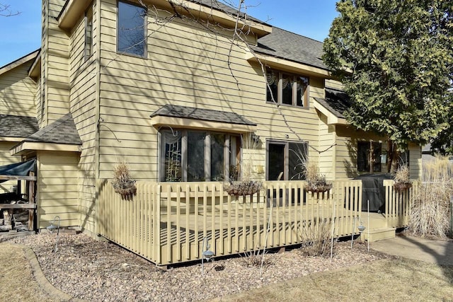 back of property with a shingled roof