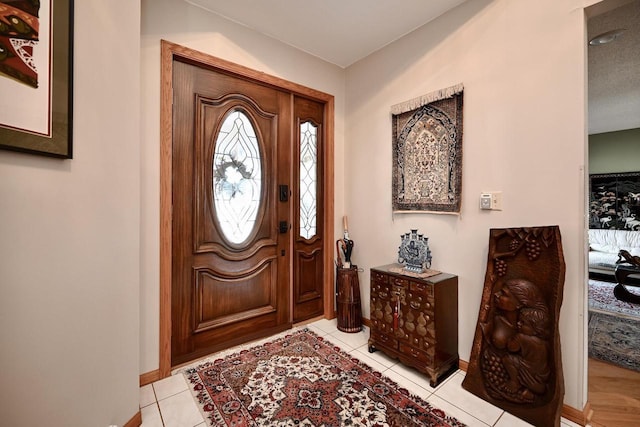 entryway featuring light tile patterned flooring and baseboards