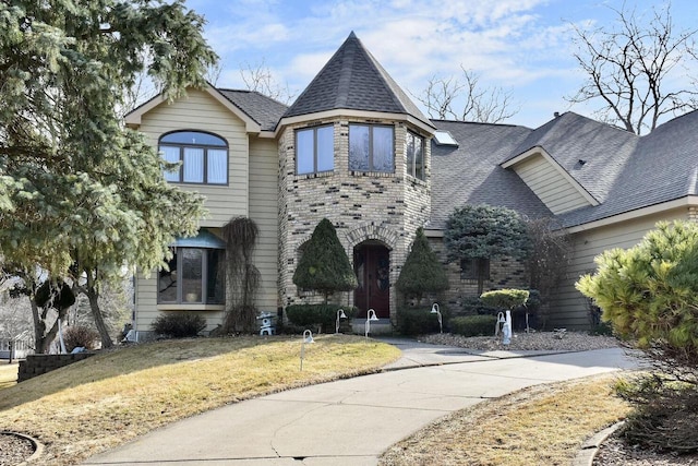 view of front of property with concrete driveway, a front lawn, and roof with shingles