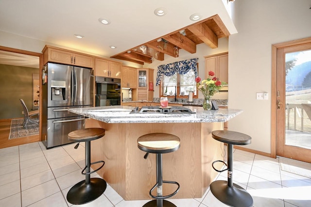 kitchen with light tile patterned floors, recessed lighting, stainless steel appliances, and a kitchen bar