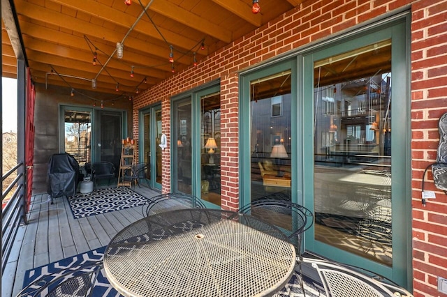 wooden deck with outdoor dining area and area for grilling