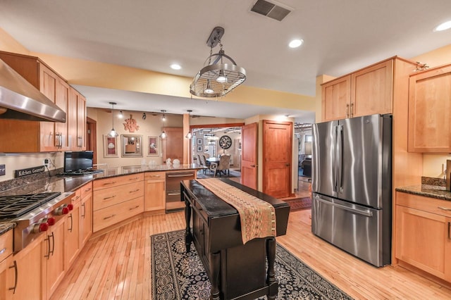 kitchen with light wood finished floors, visible vents, light brown cabinetry, a peninsula, and stainless steel appliances