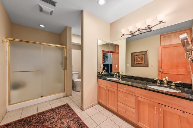 bathroom with a shower stall, toilet, double vanity, and a sink