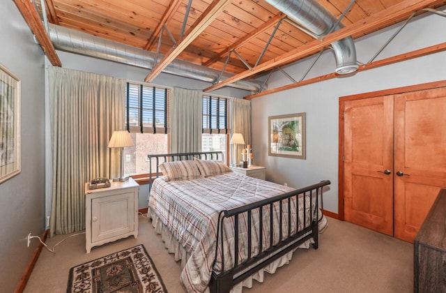 bedroom with baseboards, light colored carpet, vaulted ceiling, wooden ceiling, and a closet