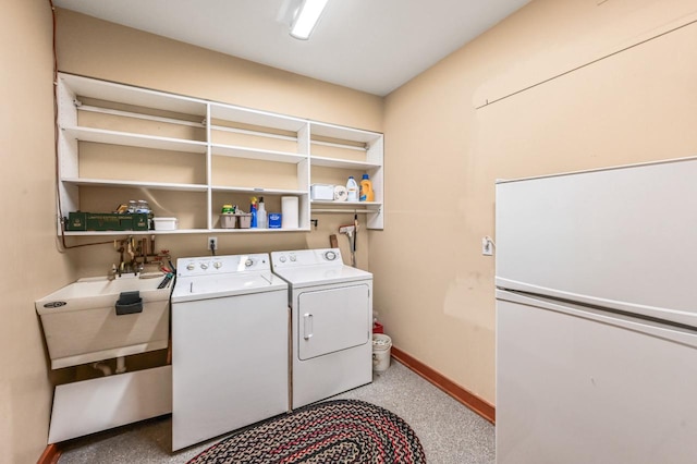 laundry room with washer and dryer, laundry area, baseboards, and a sink