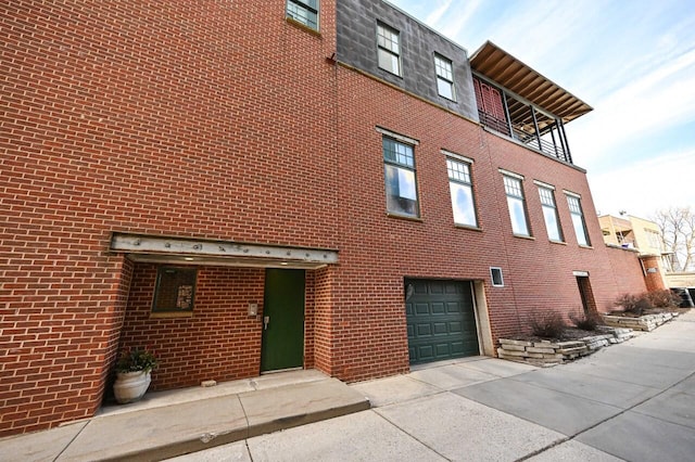 view of building exterior with an attached garage and concrete driveway