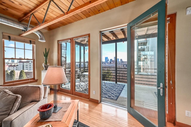 entryway featuring beamed ceiling, a view of city, wood-type flooring, baseboards, and wood ceiling