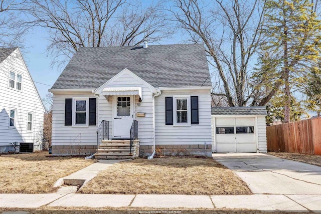 view of front of property with concrete driveway, roof with shingles, and fence