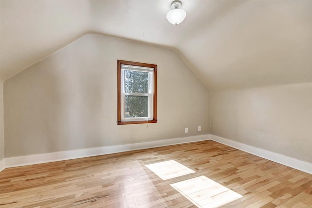 additional living space featuring lofted ceiling, wood finished floors, and baseboards