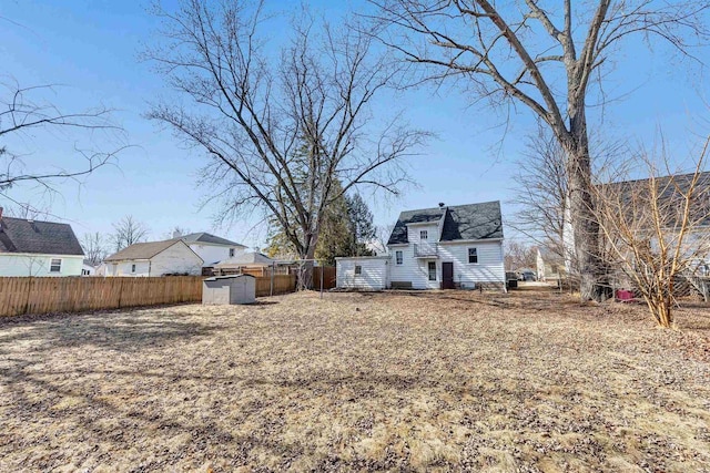 view of yard featuring a storage unit, an outbuilding, and fence