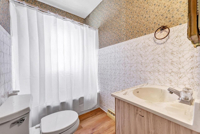 bathroom featuring toilet, wallpapered walls, tile walls, and wood finished floors