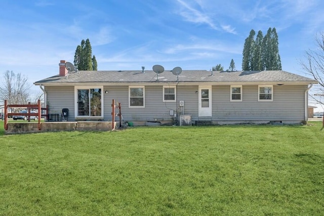 back of house featuring a chimney and a yard