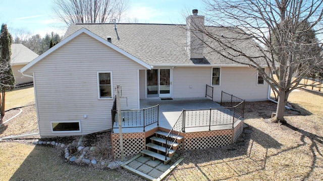 back of property featuring a wooden deck, roof with shingles, and a chimney