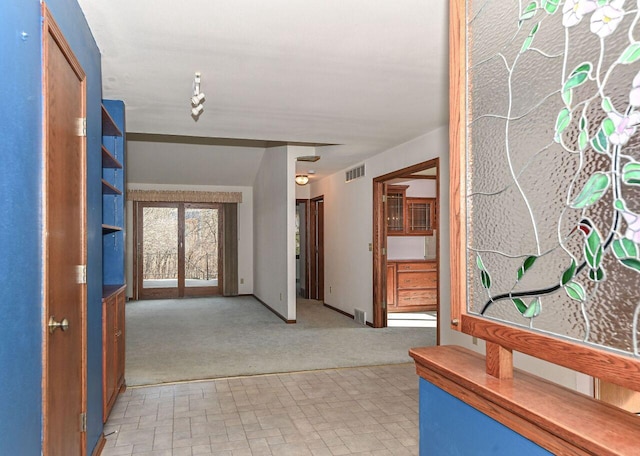 hallway with light carpet and visible vents