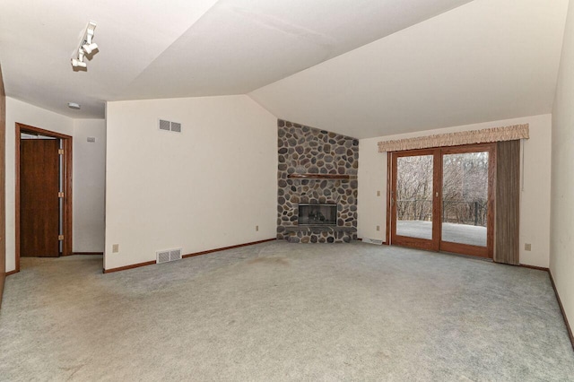 unfurnished living room with visible vents, a fireplace, carpet flooring, and vaulted ceiling