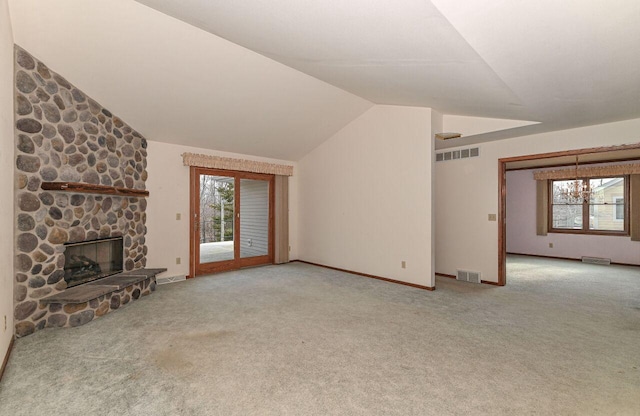 unfurnished living room with vaulted ceiling, carpet flooring, a fireplace, and visible vents