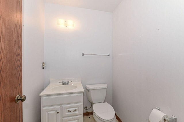 half bath featuring baseboards, toilet, and vanity