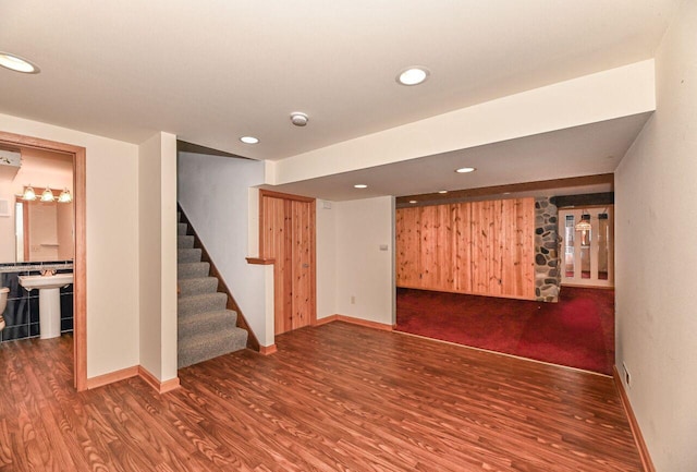 finished below grade area featuring recessed lighting, stairs, baseboards, and wood finished floors