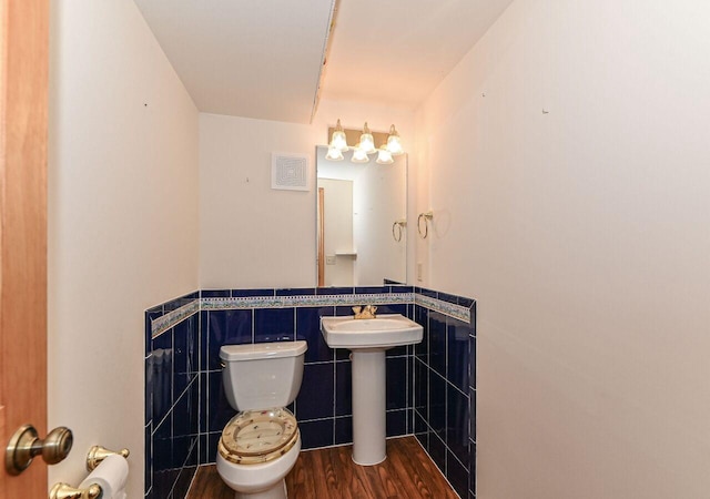 bathroom with tile walls, toilet, wood finished floors, and wainscoting