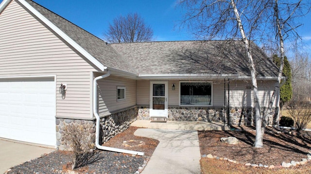 view of exterior entry featuring a porch, an attached garage, stone siding, and a shingled roof