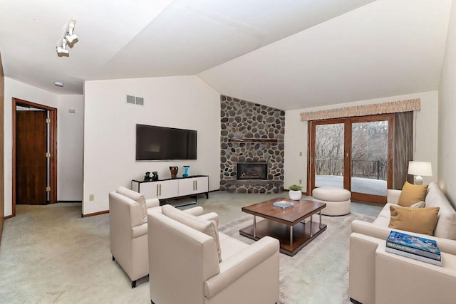 living room with visible vents, baseboards, lofted ceiling, a fireplace, and light colored carpet