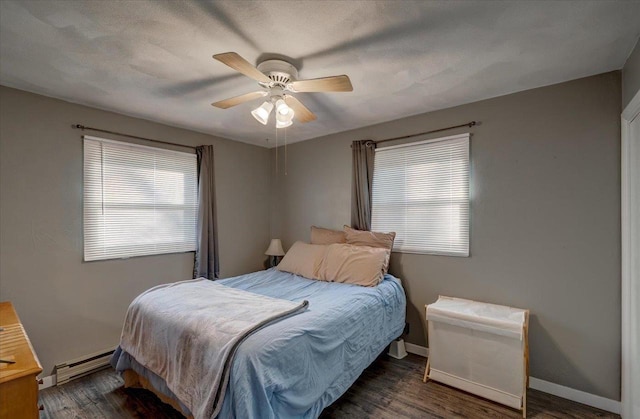 bedroom featuring ceiling fan, wood finished floors, baseboards, and a baseboard radiator