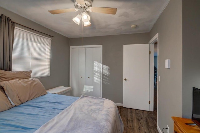 bedroom featuring a ceiling fan, wood finished floors, a closet, and baseboards