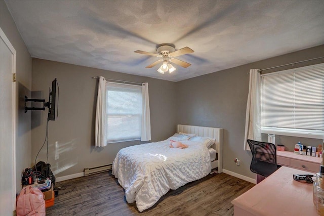 bedroom with ceiling fan, baseboards, wood finished floors, a textured ceiling, and a baseboard radiator