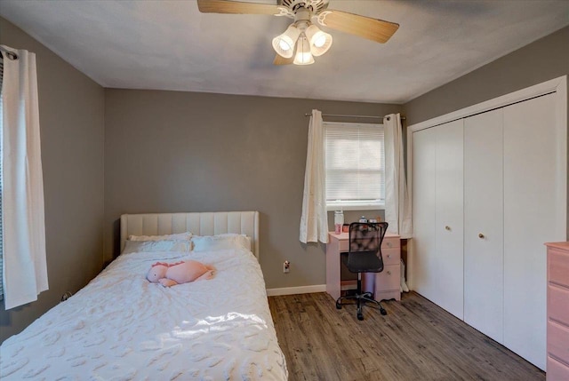 bedroom featuring wood finished floors, baseboards, a closet, and ceiling fan