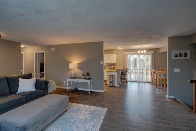 living room featuring baseboards, dark wood-style flooring, and a chandelier