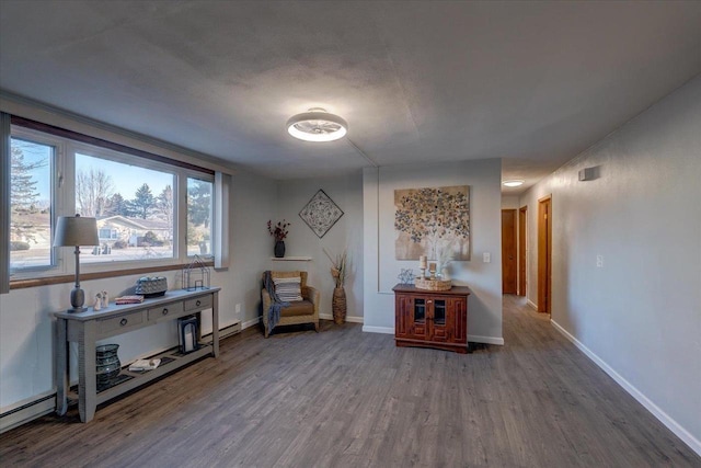 living area featuring wood finished floors, baseboards, and baseboard heating