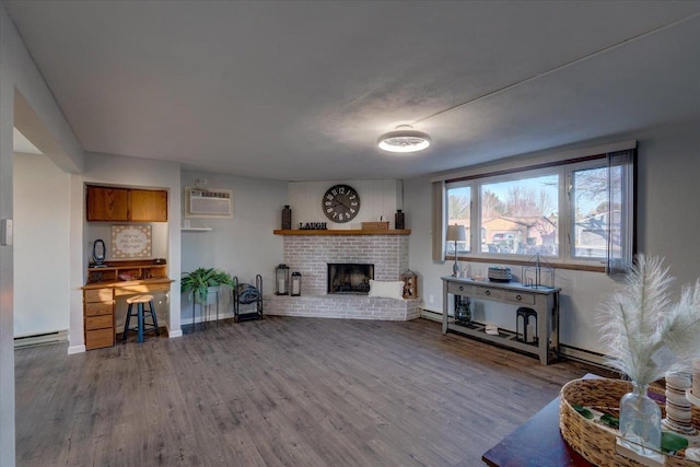 living room with a baseboard heating unit, baseboards, a wall mounted air conditioner, a fireplace, and wood finished floors