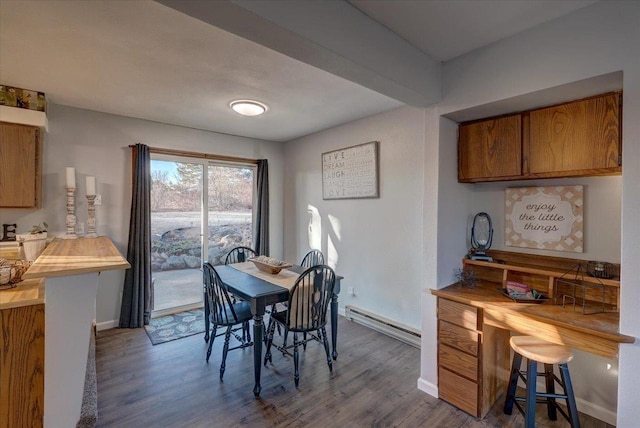 dining space featuring wood finished floors, baseboards, and baseboard heating