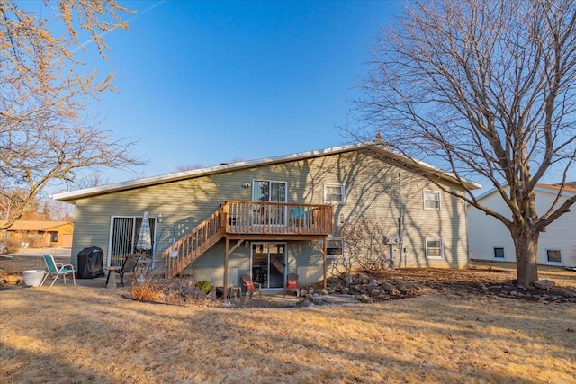 rear view of house featuring stairs and a wooden deck