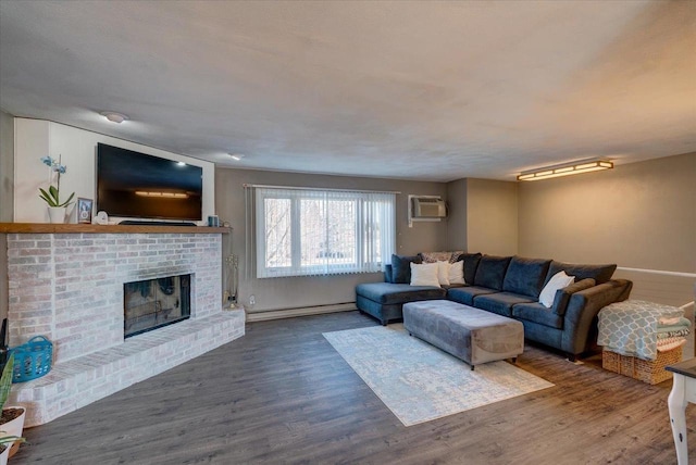 living room with wood finished floors, baseboards, a wall mounted AC, a fireplace, and a baseboard heating unit