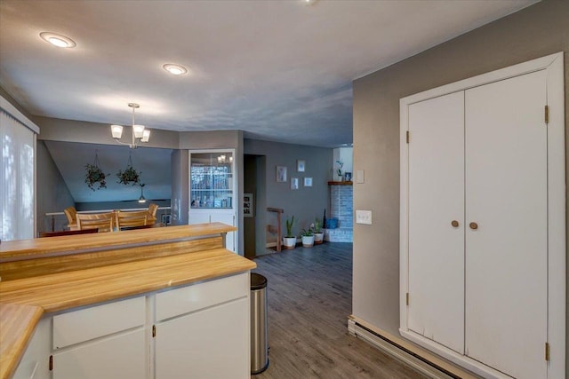 kitchen featuring white cabinetry, wood finished floors, and butcher block counters