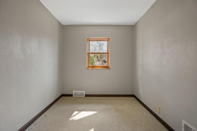 unfurnished room with visible vents, baseboards, and carpet