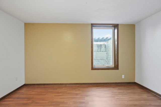 unfurnished room with wood finished floors and baseboards