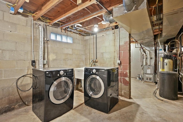 clothes washing area featuring heating unit, laundry area, and separate washer and dryer