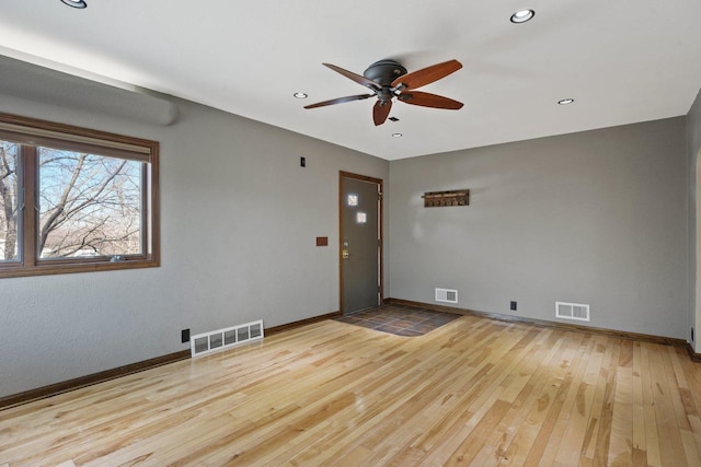 spare room with visible vents, baseboards, ceiling fan, and wood-type flooring