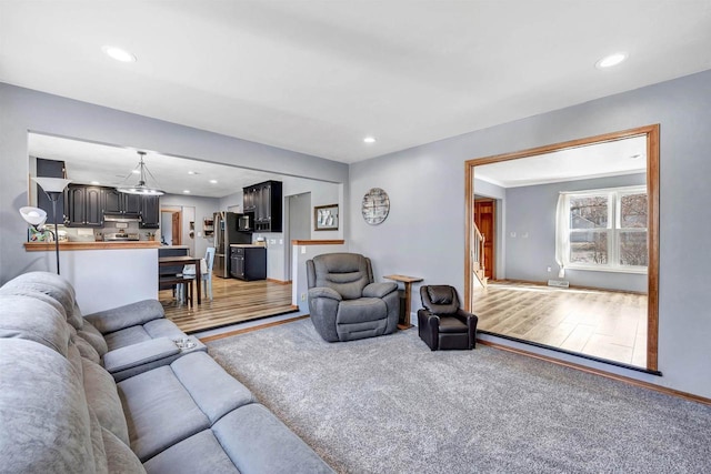 living room with recessed lighting, light wood-style floors, and light carpet