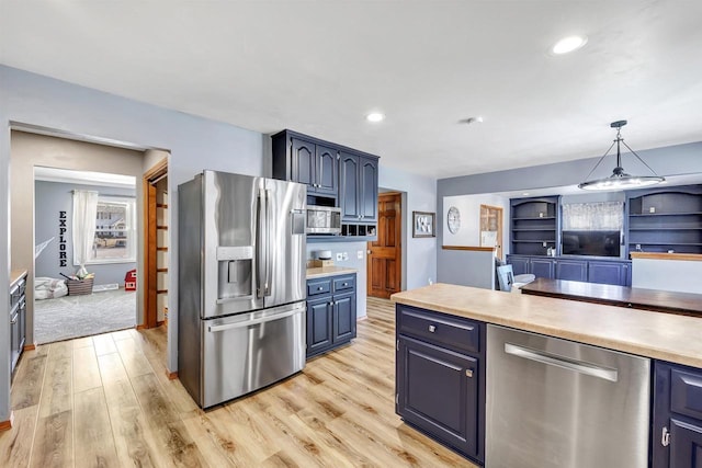 kitchen featuring blue cabinets, appliances with stainless steel finishes, light countertops, and light wood finished floors